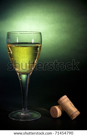 White wine in a glass, on black-green background. Luxury art
