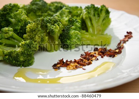 Steamed Broccoli with oil and chilli pepper in a white dish