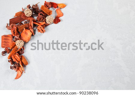 Orange autumnal decorations of dried flowers over light blue Damask pattern great for greeting cards