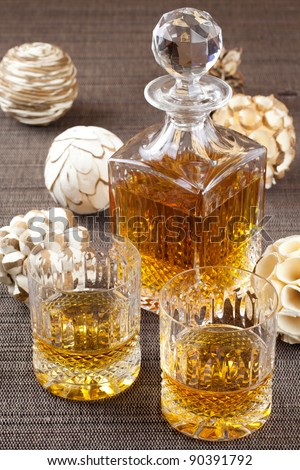 Fine bourbon whiskey in crystal bottle and tumbler glasses with stylish spheres