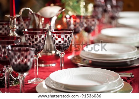 Banquet with red table setting. Red tablecloth, white dishes, silver cutlery and red checked goblet glasses plus some decorations