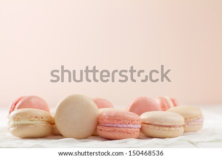 French macarons on white wood table with lace over Soft pink and white hues with copy space. A fresh, feminine image.