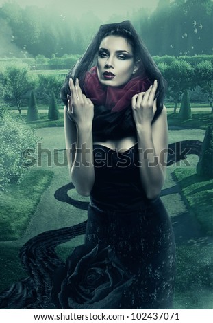 mysterious woman in black hood in garden