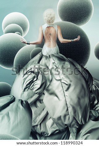 blond woman in long grey dress with spheres