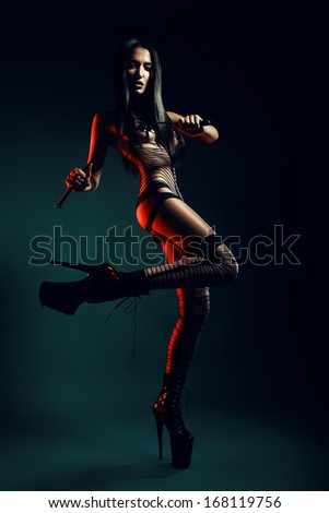 bdsm woman with whip in red light