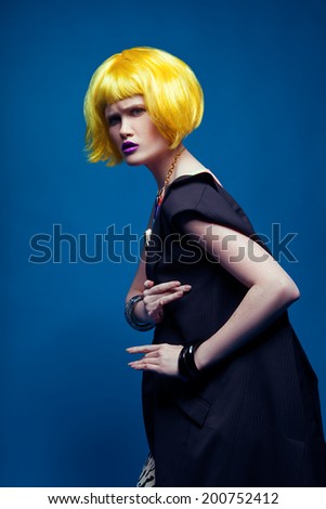 Fashion shot of a woman in a yellow wig and black costume