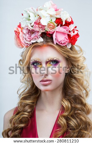 Portrait of a woman with curly hair and flowers on her head close-up