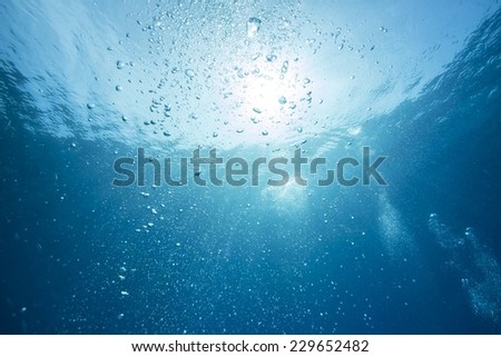 Abstract underwater scene sunrays and air bubbles in deep blue sea