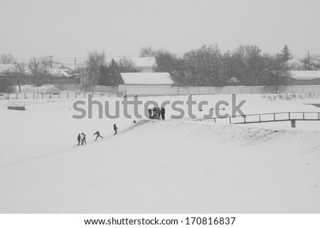 Winter landscape with fields and people enjoying the snow. Snowing makes a lovely grain-like texture