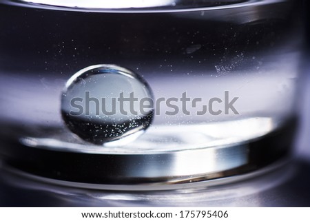 Abstract composition with round glass ball and round transparent vase and water