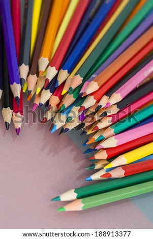 Group of sharp colored pencils with white and red background and reflexions