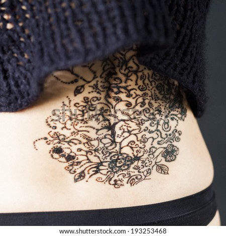 Henna tattoo on parts of a woman body with black background