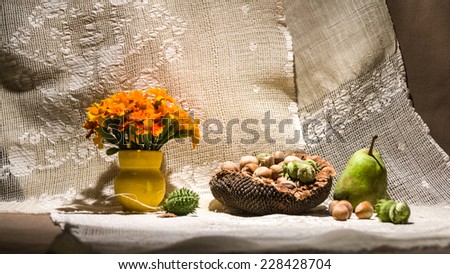 Still life composition with orange flowers and fruits