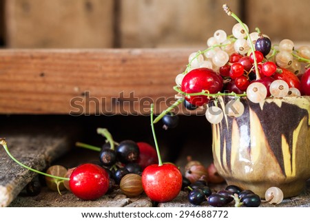 Currants, cherries and other summer fruits with old wood texture