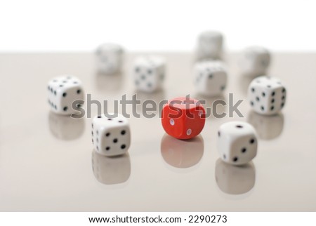 One red dice among many white dices