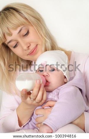 cute mom feeding baby on a white