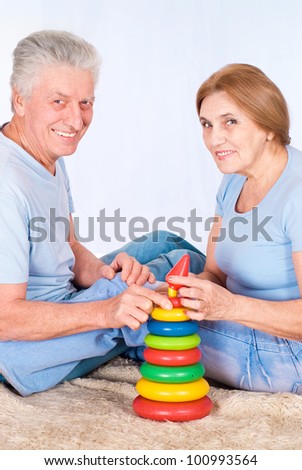 old couple on carpet with a toy