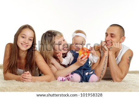 nice family of four people lying on the carpet on background