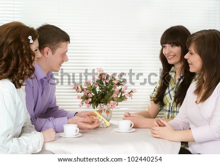 Beautiful Caucasian charming company of four men sitting at a table in a cafe