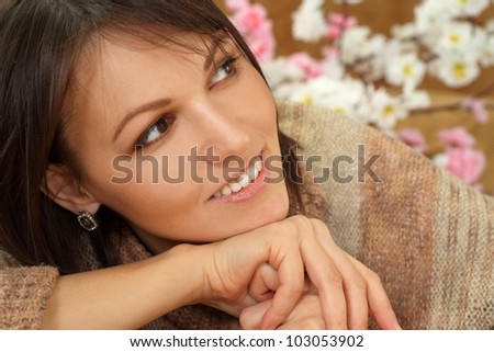 Luck charming Caucasian lady sitting on a sofa on a brown background