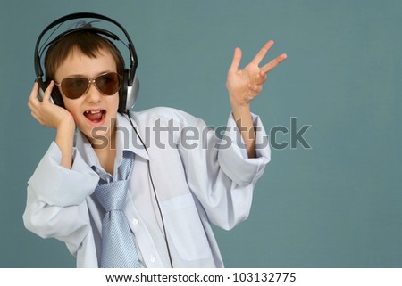 Caucasian handsome young guy with headphones posing on a turquoise background