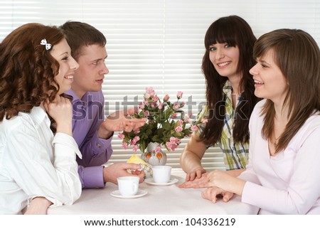 Nice Caucasian charming company of four men sitting at a table in a cafe