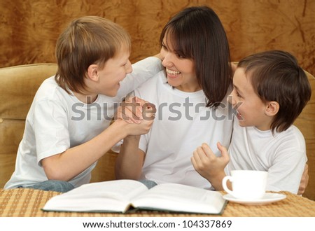 Beautiful good mom and sons sitting on a brown background