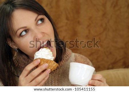 Nice Caucasian woman sitting at a table with a cake on a brown background