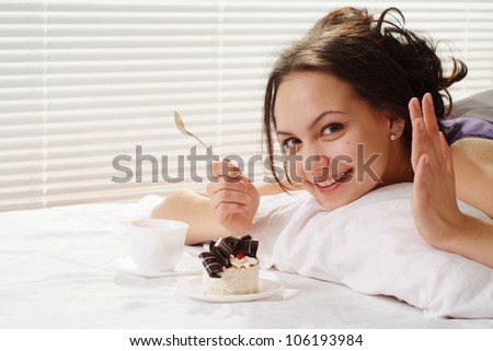 Luck Caucasian woman lying in a bed of cake on a light background
