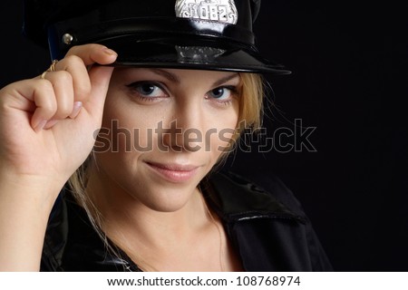 Fine girl in a uniform of  police officer on a black background