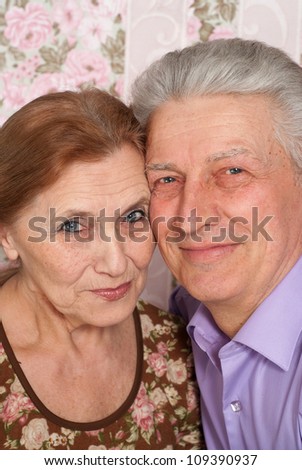Beautiful older woman in a blouse with flowers and her husband