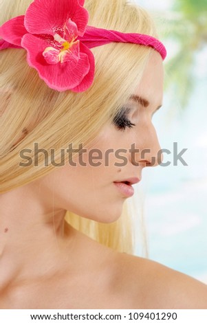 Beautiful blonde with a bright appearance is resting at a resort