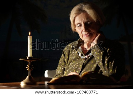 Happy old woman at home on a dark background