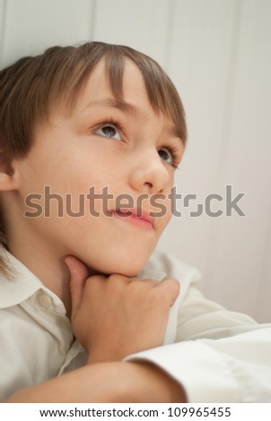 Interesting little boy sitting in a room at home