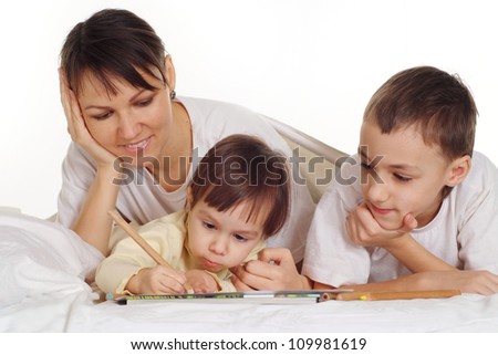 pretty mom with her young children are lie on the floor together