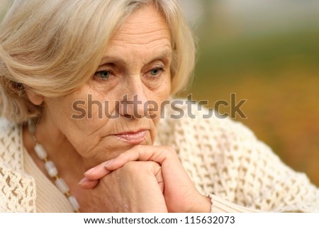 Portrait of a serious middle-aged women a soft autumn background