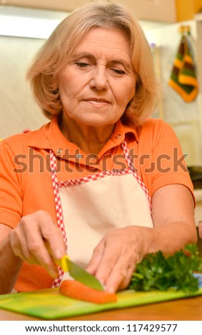 happy elderly woman preparing food in the kitchen