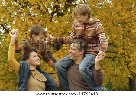 portrait of a beautiful happy family playing in autumn park