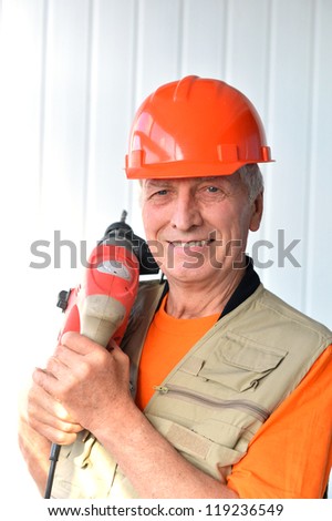 portrait of a smiling jack of all trades with a tool