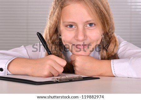 portrait of a nice girl studying at a table on a light background