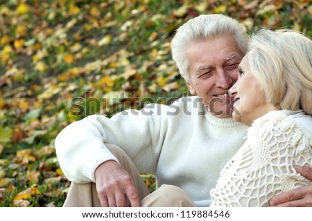 portrait of a elderly couple sitting in autumn park