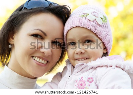 portrait of a nice mother and a little girl in the autumn