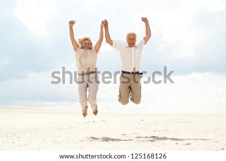 Charming elderly couple went to the beach to enjoy the sea breeze