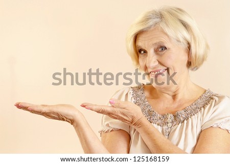 happy older woman on a beige background