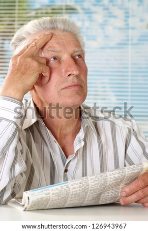 elderly man sitting  on a light background