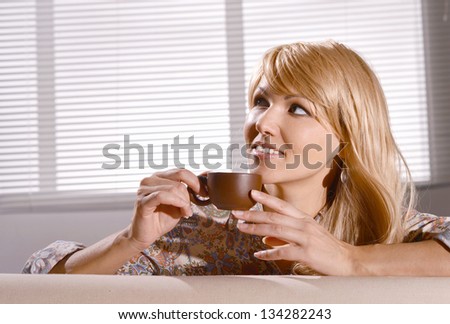 portrait of a beautiful young woman with a cup of coffee at home