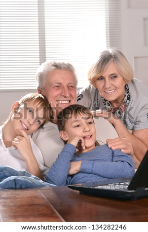 Portrait of two boys and grandparents with a laptop at home