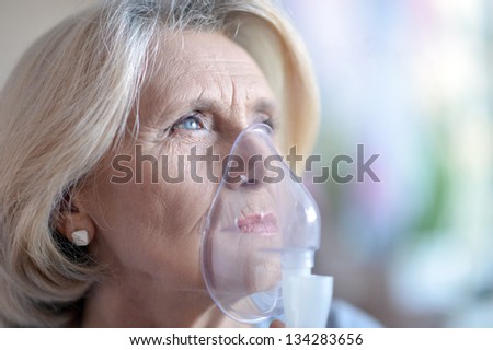 close-up portrait of an elderly woman making inhalation