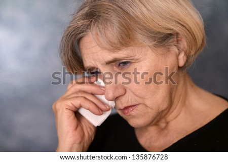 depressed old woman  on a gray background