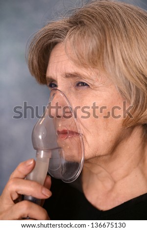 close-up portrait of an elder woman making inhalation